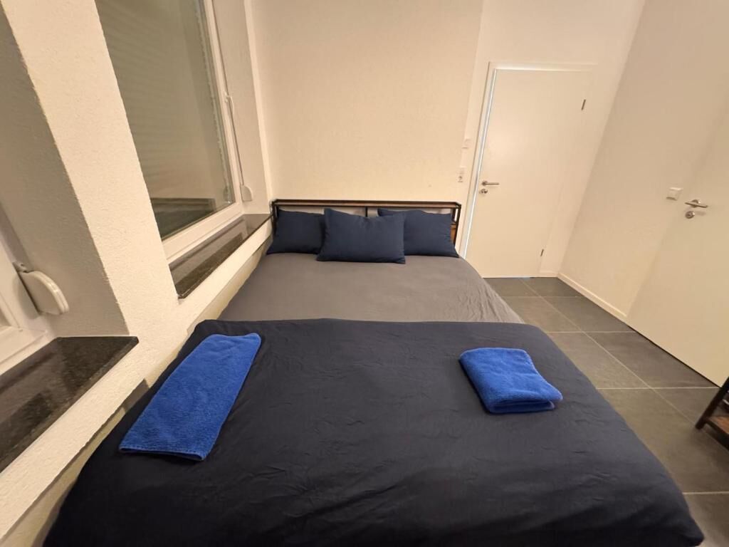 Una habitación con una cama, una ventana y una puerta.