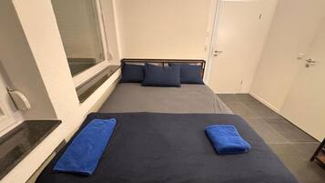 Una habitación con una cama, una ventana y una puerta.