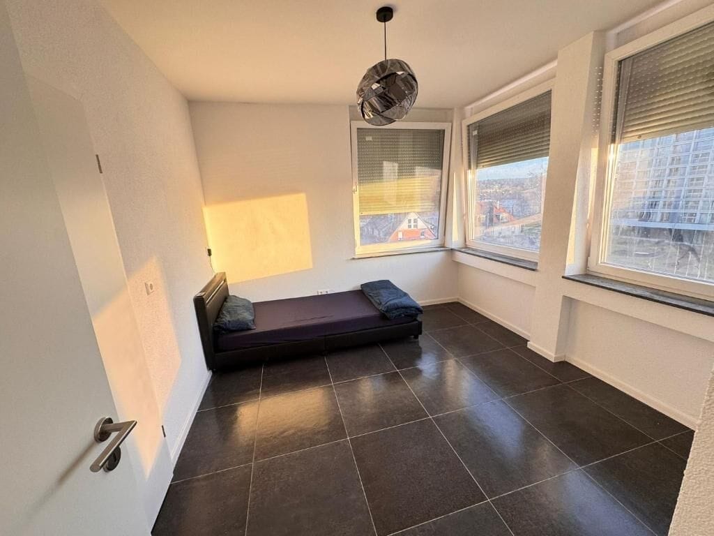A room with a bed, a window, and a door.
