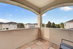 Ein Balkon mit Blick auf angrenzende Häuser und einen klaren Himmel.