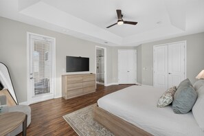 A bedroom with a bed, a TV, a dresser, and a ceiling fan. - 5BR Encore Sleeps 12 w/ Pool, Spa & Game Tables (Kissimmee)