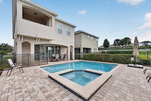 A two-story house with a swimming pool, outdoor furniture, and a fenced patio area. - 5BR Encore Sleeps 12 w/ Pool, Spa & Game Tables (Kissimmee)