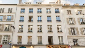 A multi-story building with a flat facade, multiple windows, and balconies. - Spectacular 6 bedroom in the Heart of the Opéra District (Paris)