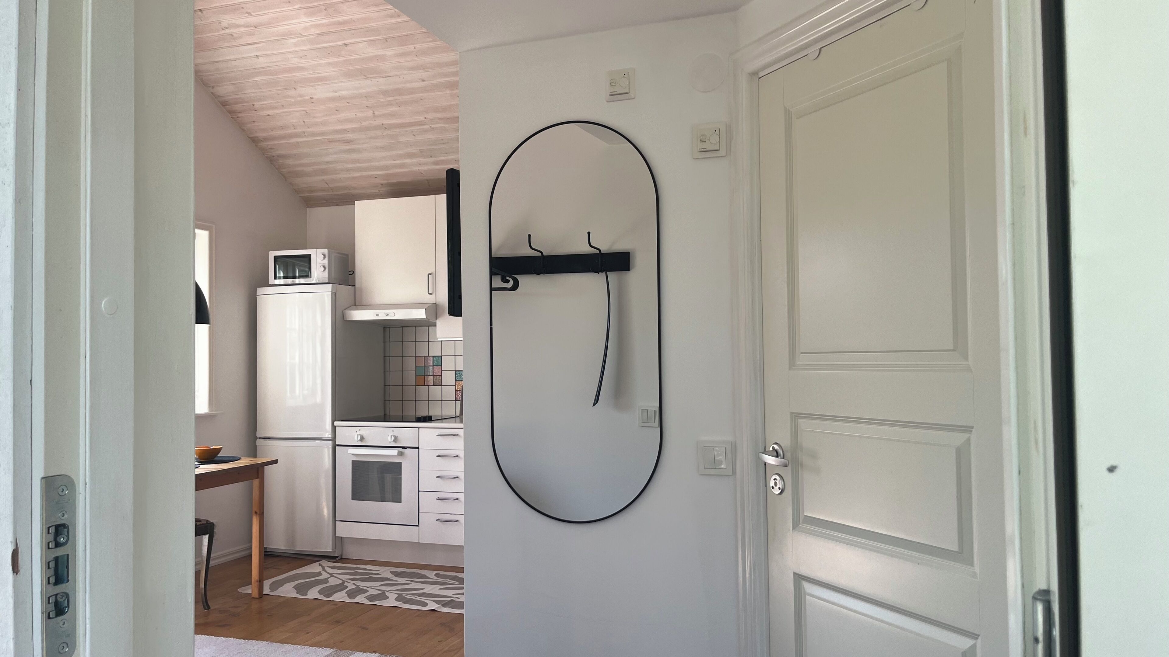 Una cocina compacta con gabinetes blancos, un microondas y una estufa.