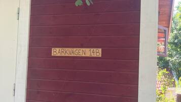 Uma porta de madeira com uma placa que diz 'BARKVAGEN 14B'.