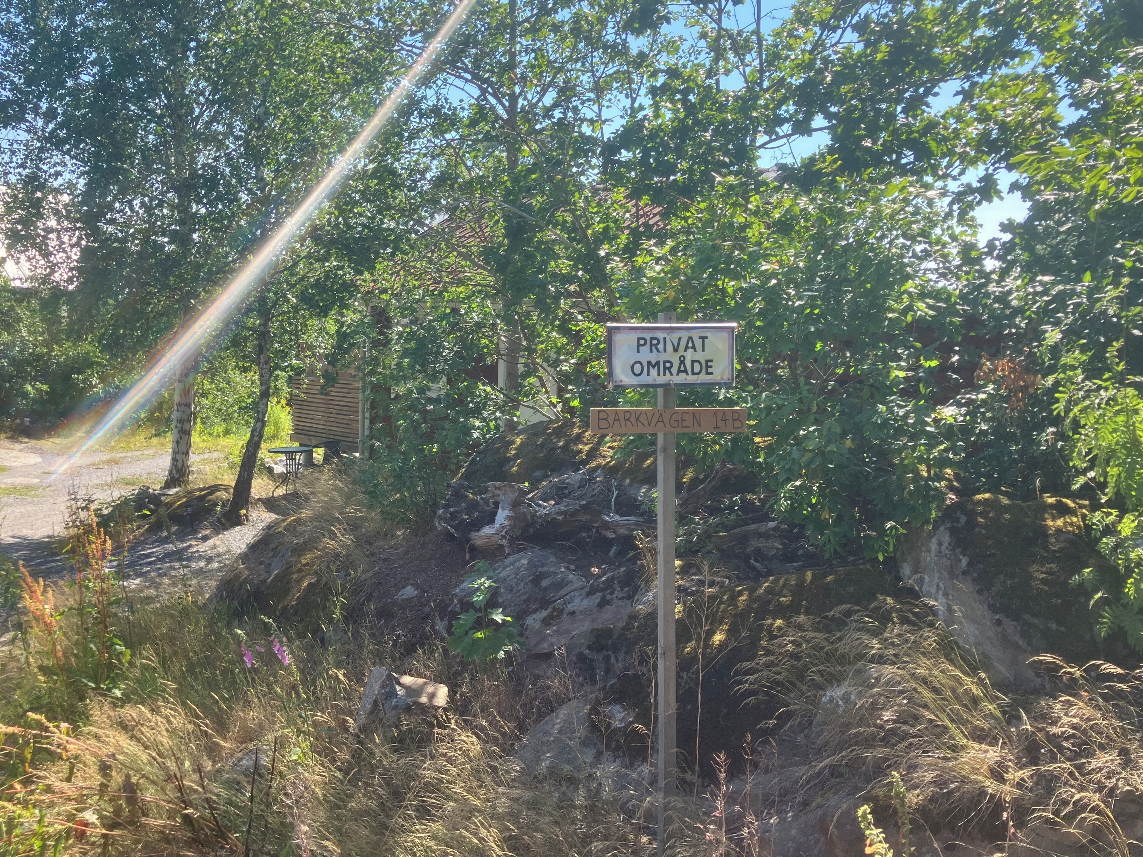 Un cartel con la inscripción 'PRIVAT OMRADE' y 'BARKVAGEN 14B' indica una propiedad privada y una ubicación específica.