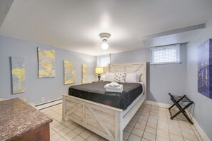 A bedroom with a bed, a nightstand, a lamp, and artwork on the walls. - Historic Cleveland Hideaway Near Downtown! (Cleveland)