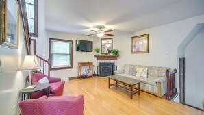 A living room with a fireplace, a sofa, a coffee table, and a television. - 6 Mi to Dtwn! Historic Haven in Cleveland (Cleveland)