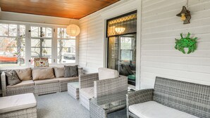 A covered porch with wicker furniture, a glass table, and a decorative wall hanging. - Walk to Dtwn Clayton & River! 2-unit Getaway (Clayton)