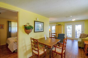 A dining area with a wooden table and chairs, a hanging plant, and a framed picture on the wall. - Walk to Beach! Water-view Fairhope Retreat (Fairhope)