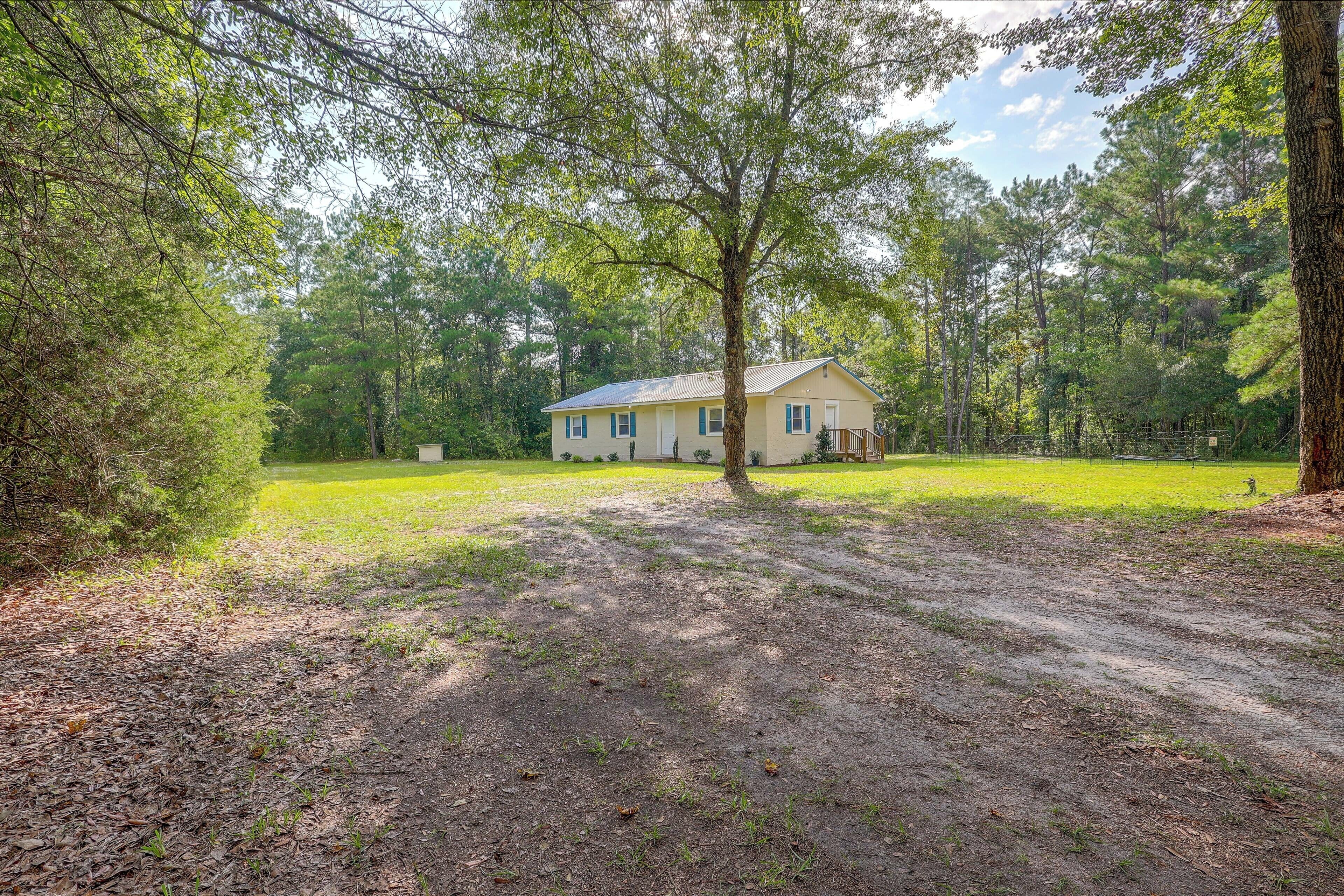 A two-story house with a front yard and a driveway leading to the entrance.