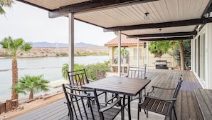 An outdoor patio with a table and chairs, overlooking a body of water and a hilly landscape. - Colorado River Family Escape in Bullhead City (Bullhead City)