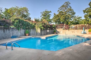 A swimming pool with a concrete deck, surrounded by a stone wall and potted plants. - 'the Wake Zone' Condo Near Lake of the Ozarks (Lake Ozark)