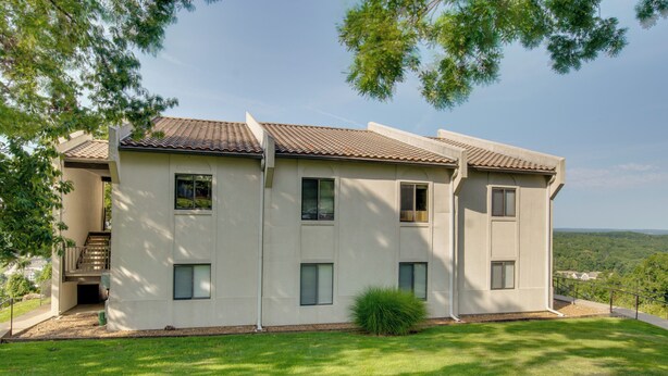 A two-story building with a tiled roof, multiple windows, and a small front porch. - 'the Wake Zone' Condo Near Lake of the Ozarks (Lake Ozark)