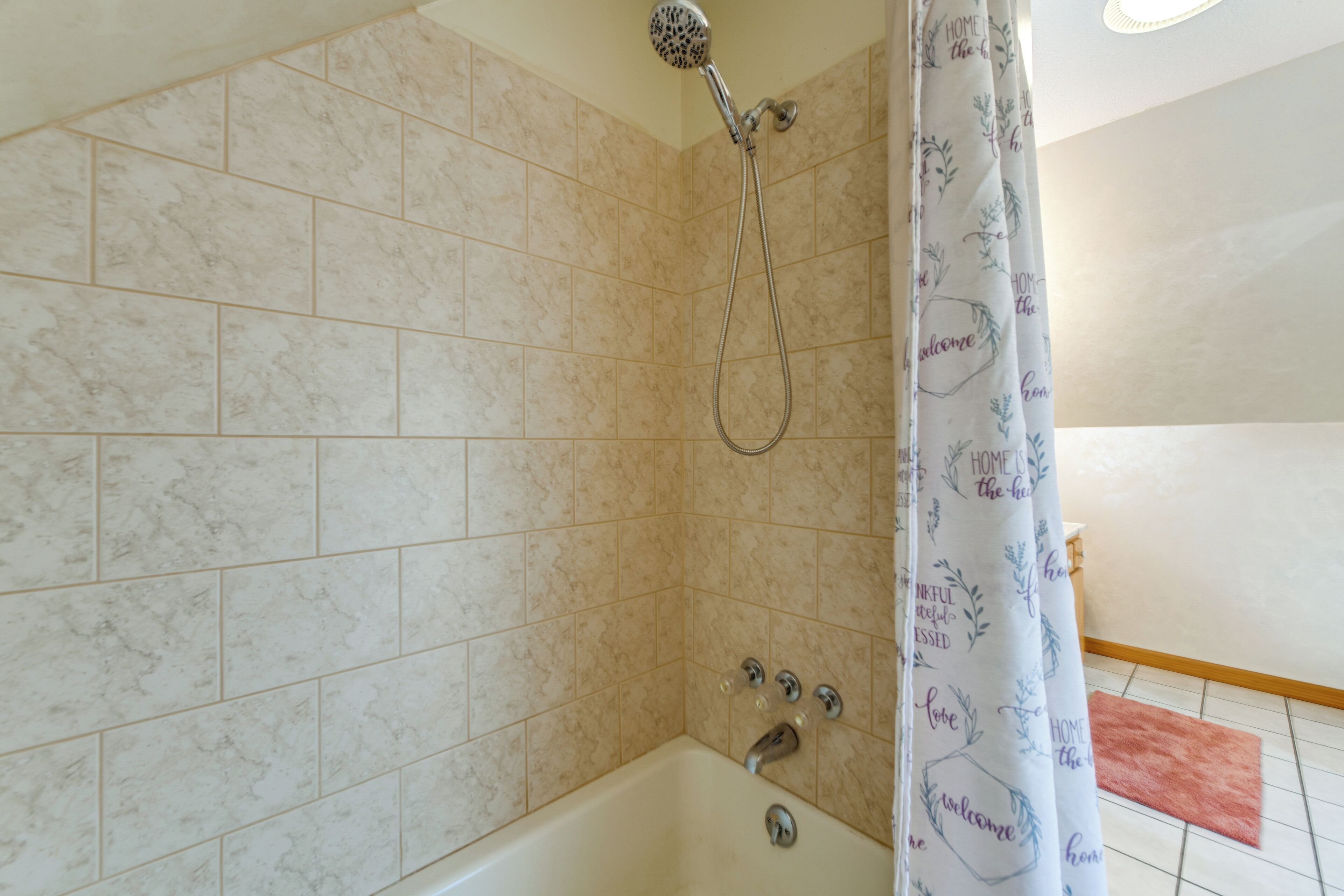 A bathroom with a shower, a bathtub, and a tiled floor.