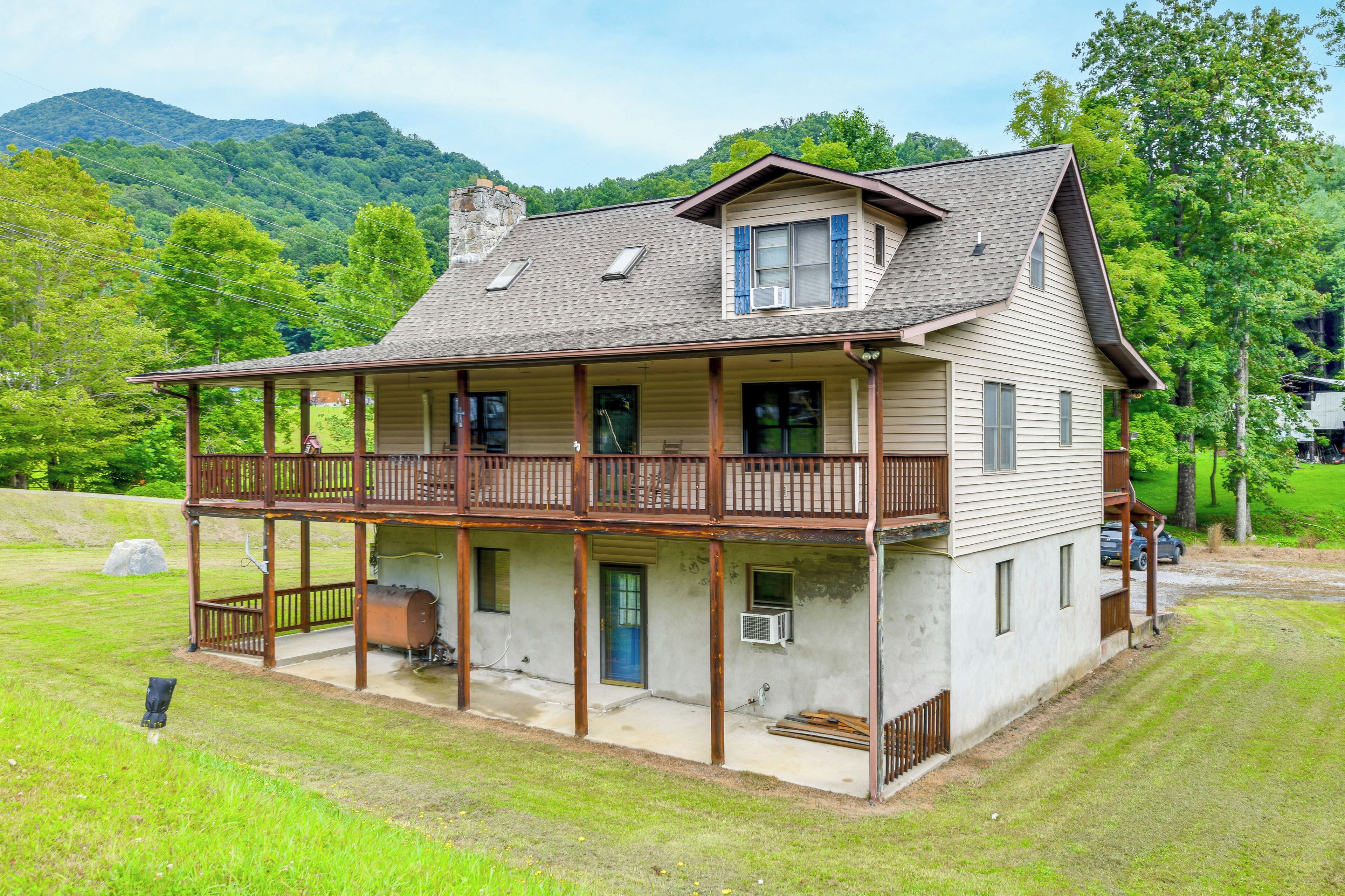 A two-story house with a balcony, a chimney, and a large front porch.