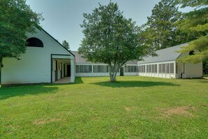 A building with a covered porch and a large tree in front.