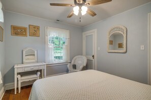 A bedroom with a bed, a chair, a desk, a ceiling fan, and two wall-mounted mirrors. - Stables & Trails! 2 Homes in Kaolin Farms (Belleview)