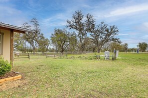 A fenced outdoor area with a building, trees, and a playground. - 5-unit Retreat Near World Equestrian Center & Hits (Morriston)