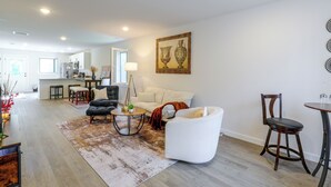 A modern living room with a sofa, armchairs, a coffee table, and a dining area with a table and chairs. - Hickory Townhome w/ Deck: 2 Mi to Downtown (Hickory)