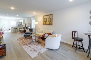 A modern living room with a sofa, armchairs, a coffee table, and a dining area with a table and chairs. - Hickory Townhome w/ Deck: 2 Mi to Downtown (Hickory)