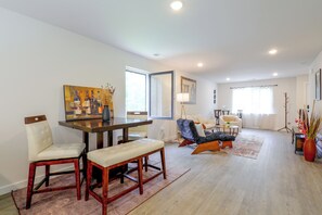 Amplia sala de estar con una mesa de comedor, sillas, un sofá y una mesa de centro.