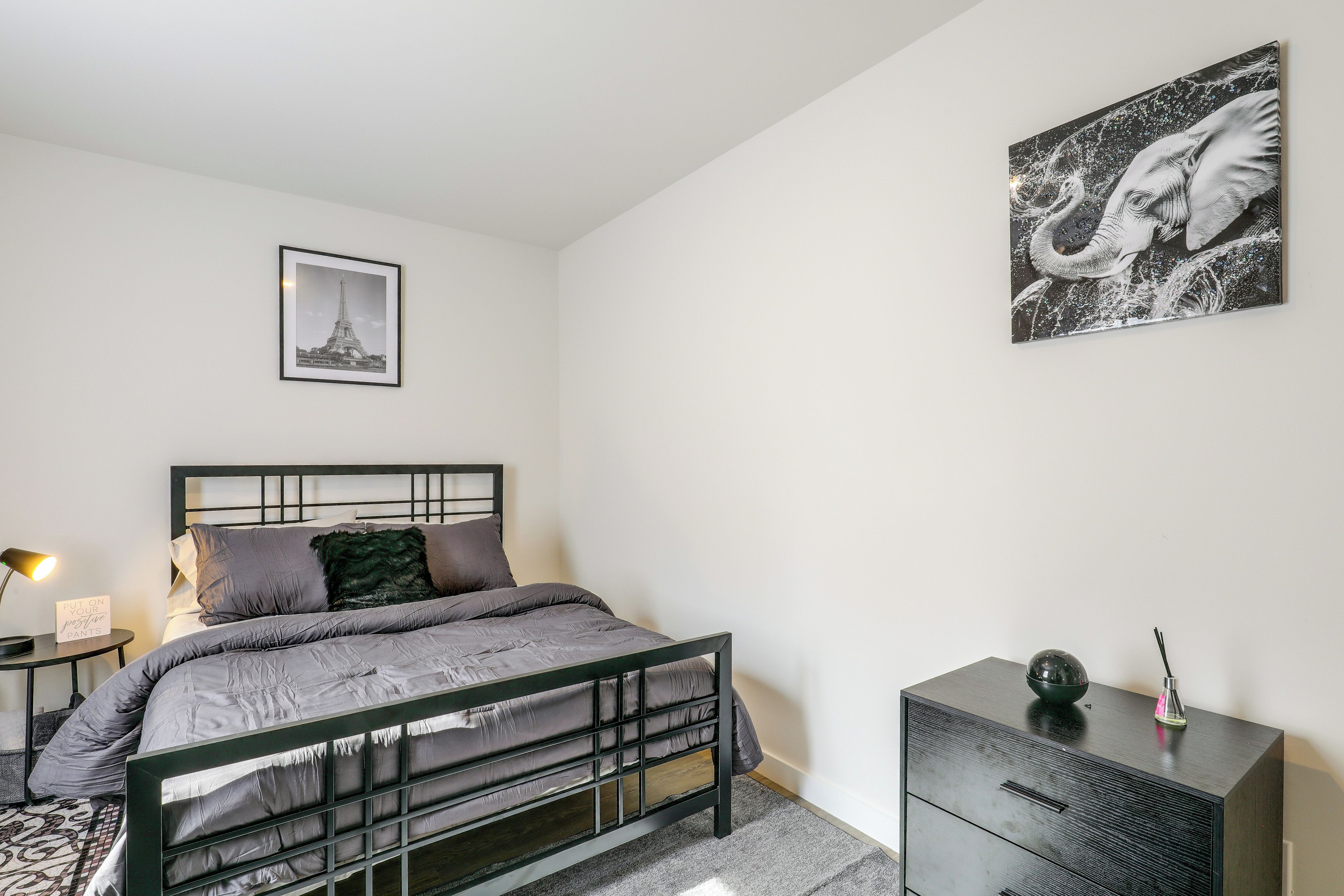 Une chambre à coucher au style minimaliste, avec un lit, une table de chevet et une commode.