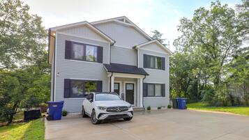 A two-story house with a driveway and a parked car.