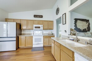 A kitchen with wooden cabinets, a white refrigerator, a microwave, an oven, and a sink. - 5 Mi to Stadiums! Quiet & Sun-soaked Peoria Oasis (Peoria)