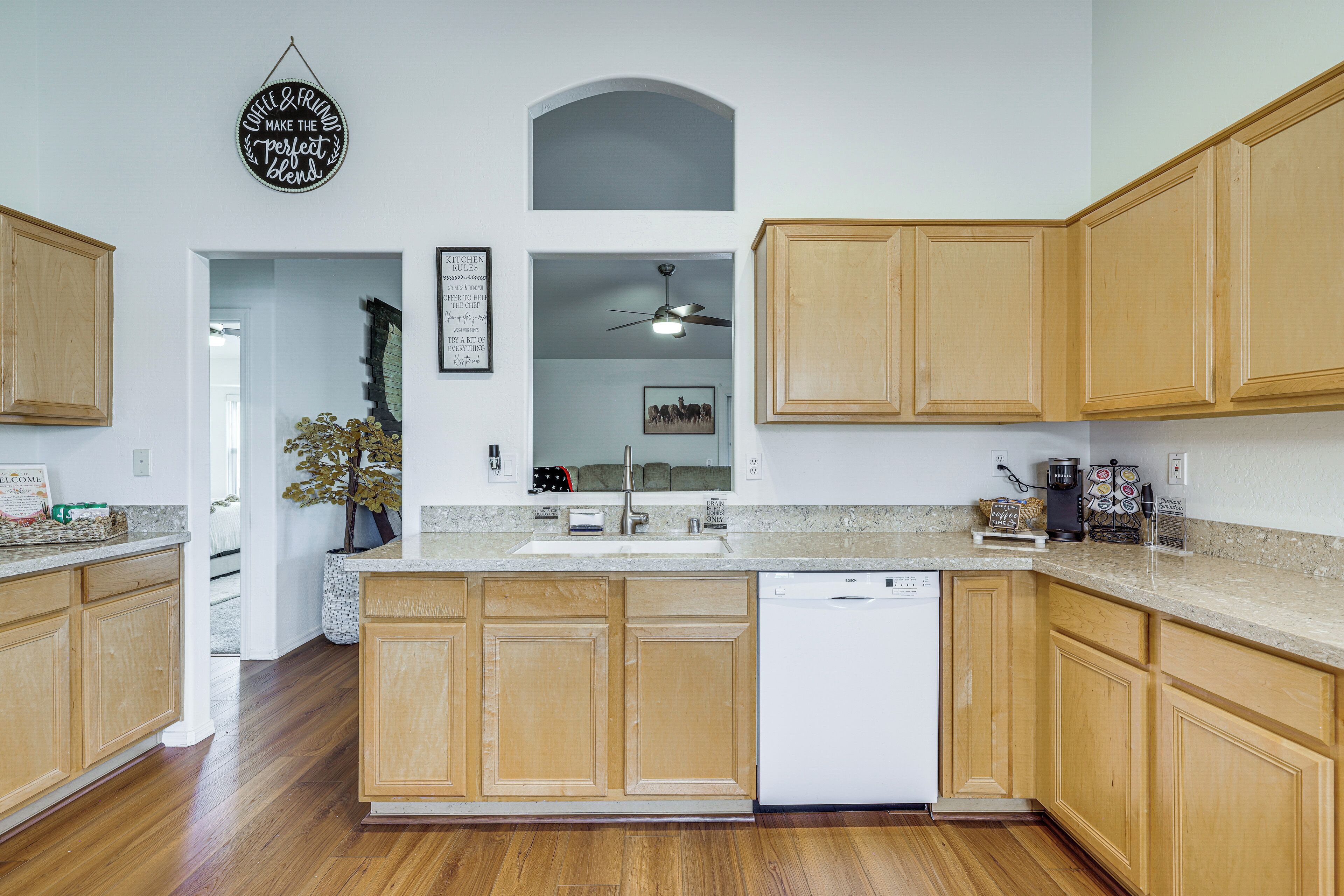 A modern kitchen with wooden cabinets, a Bosch dishwasher, and a coffee maker.
