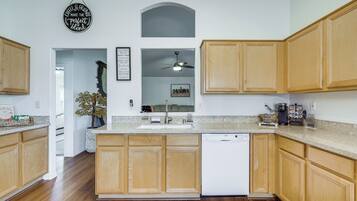 A modern kitchen with wooden cabinets, a Bosch dishwasher, and a coffee maker.