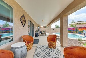 A covered patio area with seating, a pool, and a view of a colorful mural.