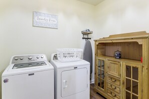 A laundry room with a washing machine, dryer, and a wooden cabinet with drawers.