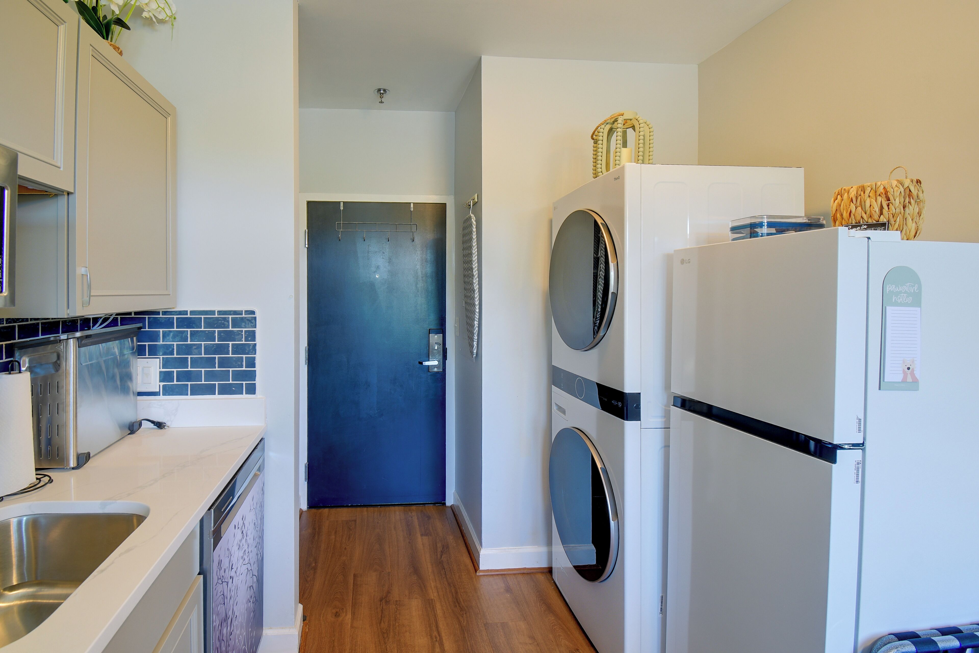 A compact kitchen with a washing machine, a refrigerator, and a sink.