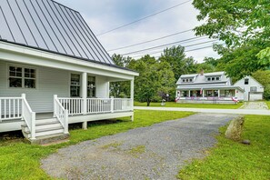 A two-story house with a porch and a gravel driveway. - Modern Farmhouse Between Mount Snow & Stratton! (Wardsboro)
