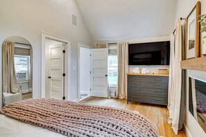 Ein Schlafzimmer mit einem großen Bett, einem Fernseher, einem Schminktisch und einem begehbaren Kleiderschrank.