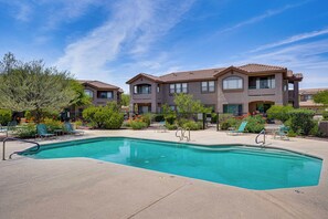 Ein Wohngebäude mit Swimmingpool, mehreren Balkonen und einem angelegten Garten.