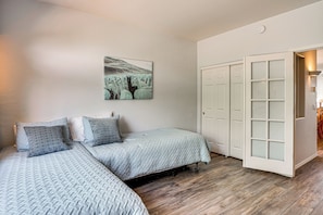 Ein Schlafzimmer mit zwei Betten, einem Kleiderschrank und einem Bild an der Wand.