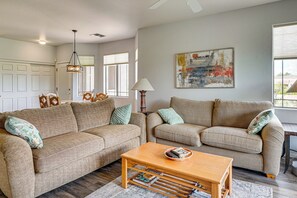 A living room with a beige sofa set, a wooden coffee table, and a painting on the wall. - Pool & Hot Tub Access! Family Condo in Oro Valley (Oro Valley)