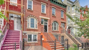 A red brick building with a pink staircase and a beige staircase. - Walk to Hblr & Liberty State Park: Jersey City Apt (Jersey City)