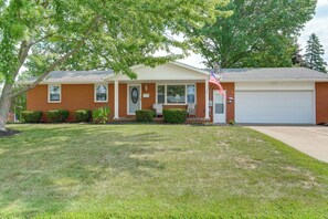 A single-story house with a garage, a front porch, and a well-maintained lawn. - Hot Tub, Gym & Office! Family Home in Massillon (Massillon)