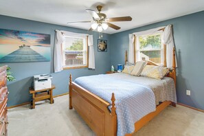 A bedroom with a bed, a ceiling fan, a desk with a printer, and a painting on the wall. - Hot Tub, Gym & Office! Family Home in Massillon (Massillon)