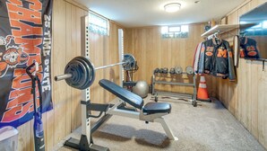 Une salle de sport équipée d’un banc de développé couché, d’haltères et d’un support à poids.