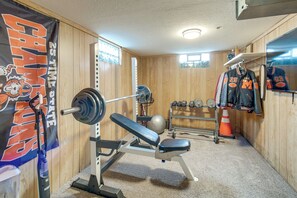 A gym with a bench press, dumbbells, and a weight rack. - Hot Tub, Gym & Office! Family Home in Massillon (Massillon)