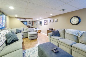A living room with a sofa set, a coffee table, and a wall clock. - Hot Tub, Gym & Office! Family Home in Massillon (Massillon)