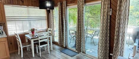 L'intérieur d'une cabine comprenant un coin repas, un canapé et un ventilateur de plafond.