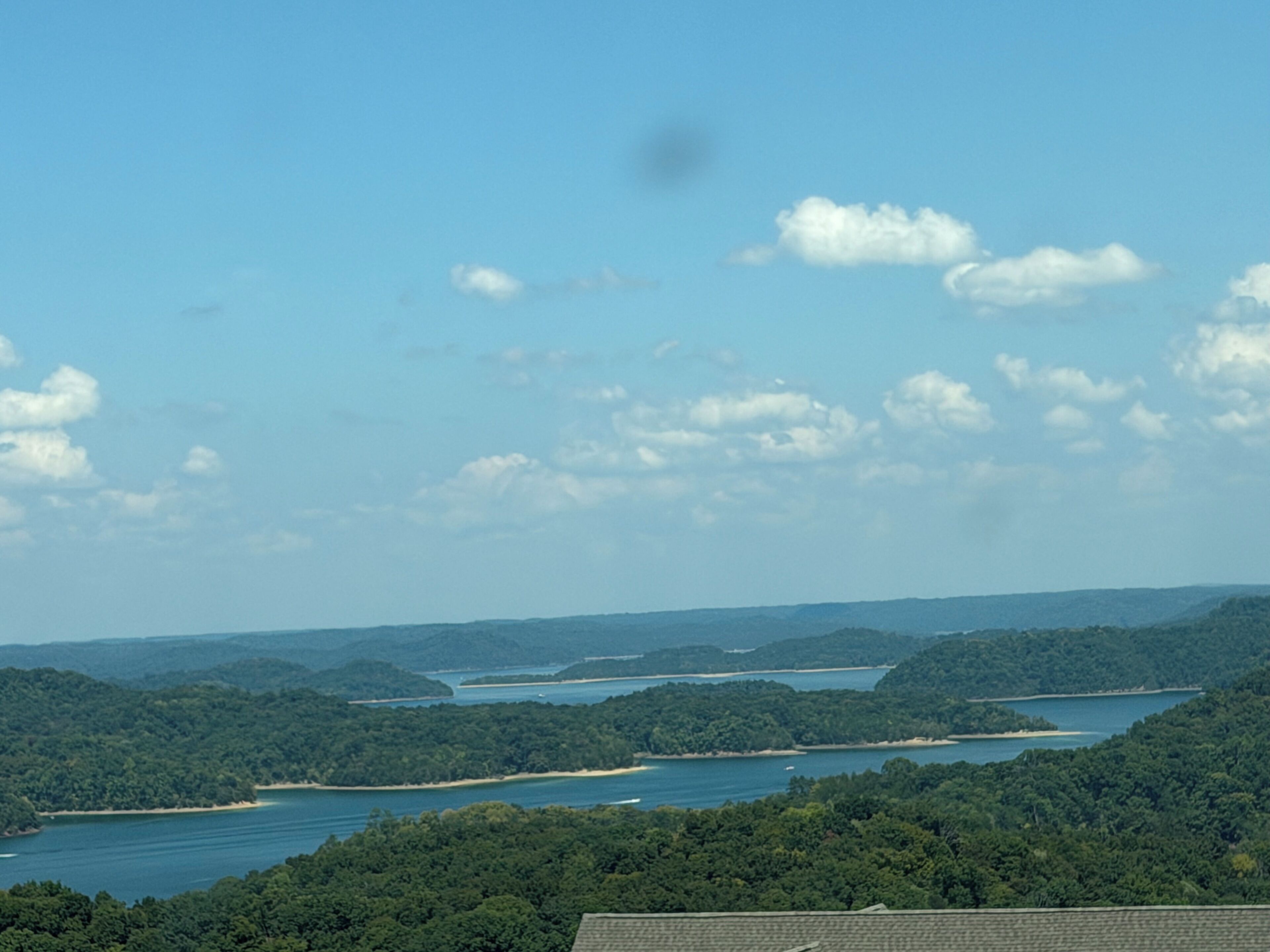 A landscape with a body of water surrounded by forested hills.