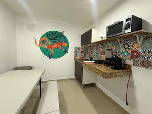 A small kitchen with a microwave, a sink, and a colorful backsplash. - Casa Villa Leo, Downtown Cancún (Cancún)
