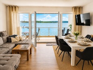 A modern living room with a sofa, coffee table, and dining area set up for a meal.