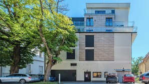 Ein modernes Gebäude mit flachem Dach, großen Fenstern und einem Garageneingang.